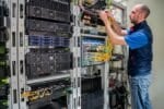 Technician works with server equipment in a data center, Shutterstock ID#2273884099.
